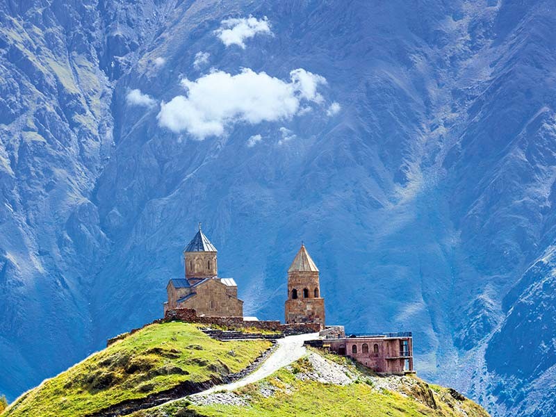 Die Kirche von Gergeti vor der Kaukasuskulisse Georgiens